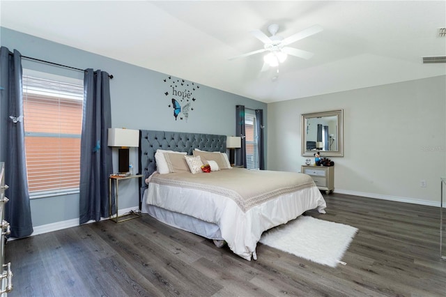 bedroom featuring ceiling fan, dark hardwood / wood-style flooring, and multiple windows