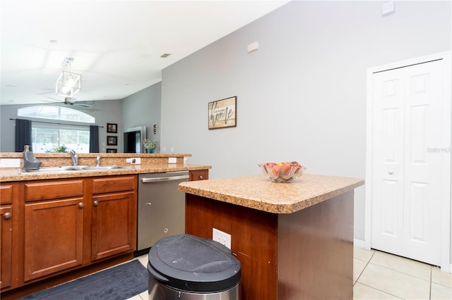 kitchen with light tile patterned flooring, sink, dishwasher, a center island, and vaulted ceiling