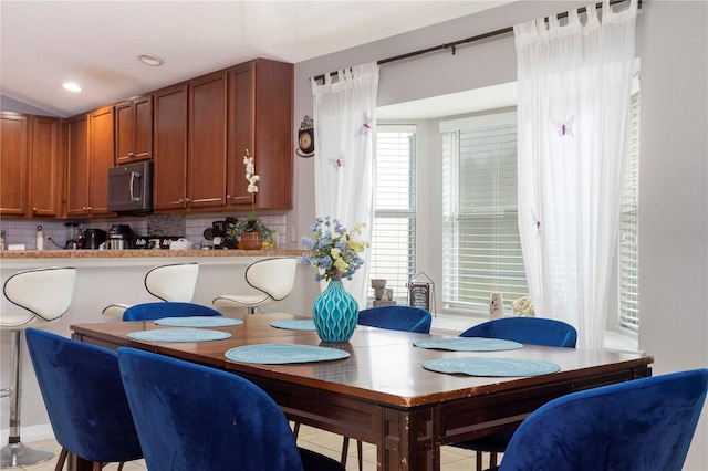 dining room featuring lofted ceiling and light tile patterned flooring