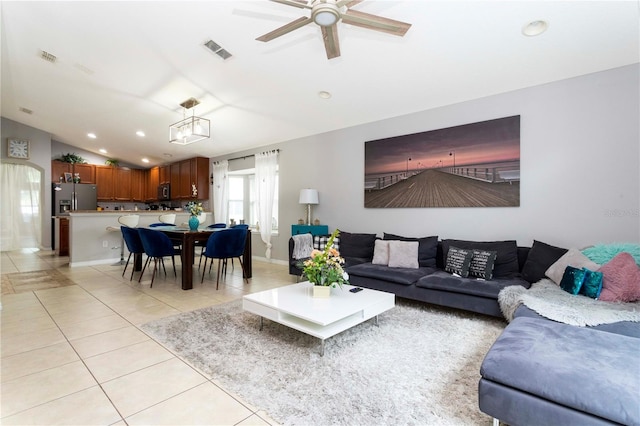 tiled living room with ceiling fan and vaulted ceiling