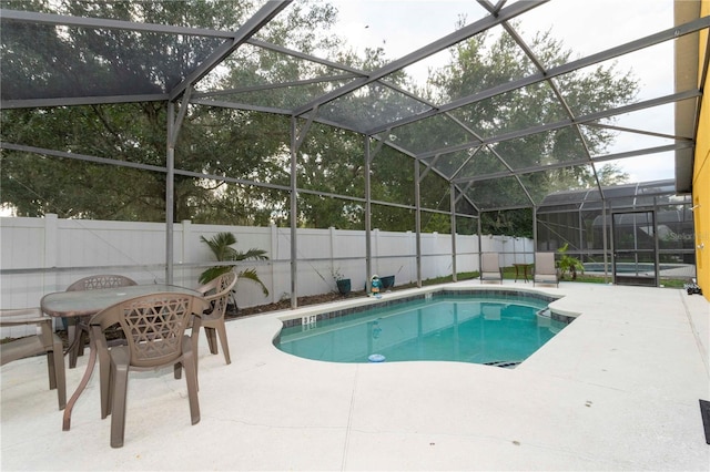 view of pool featuring glass enclosure and a patio