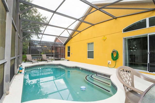 view of swimming pool with glass enclosure and a patio area