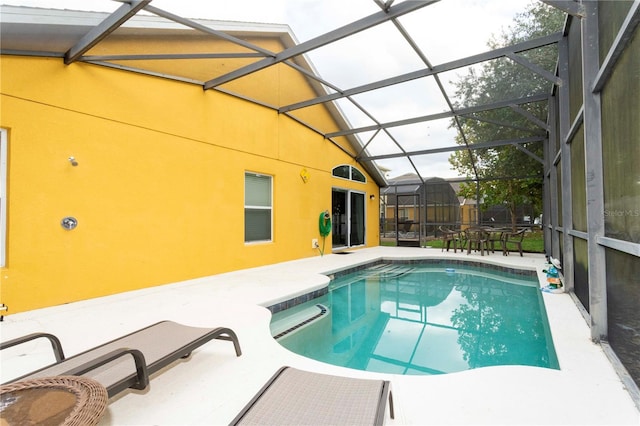 view of swimming pool featuring a patio and glass enclosure