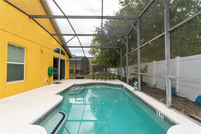 view of pool with glass enclosure and a patio area