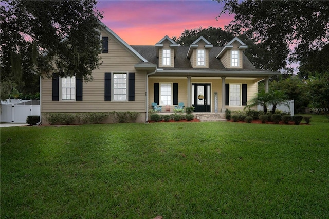 view of front of house with a porch, a front yard, fence, and a gate