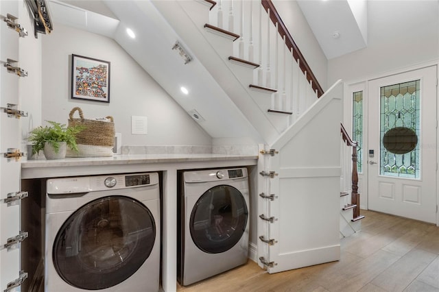 clothes washing area with light wood-type flooring and washer and clothes dryer