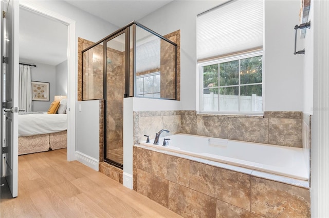 bathroom with shower with separate bathtub and hardwood / wood-style flooring