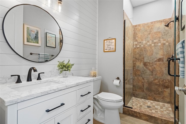 bathroom with vanity, hardwood / wood-style floors, toilet, and an enclosed shower