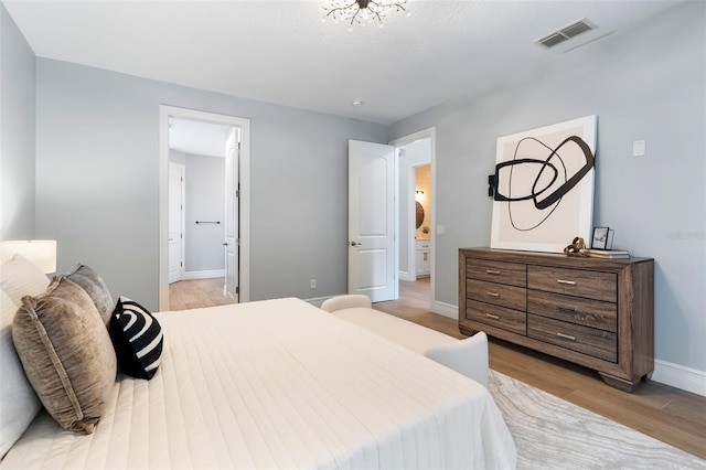 bedroom featuring baseboards, visible vents, and light wood-style floors