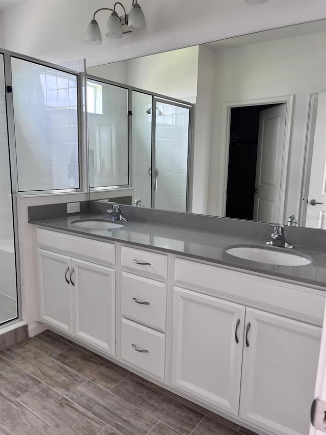 bathroom with a shower with door and vanity