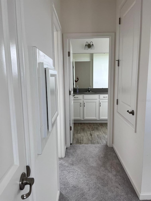 hallway with sink and carpet