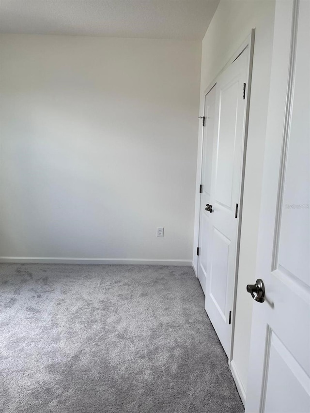 unfurnished room with dark carpet