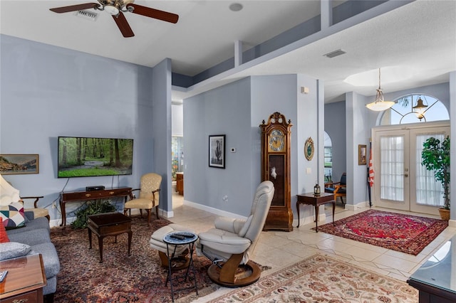 living room featuring french doors, light tile patterned floors, and ceiling fan