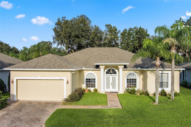 ranch-style home with a garage, french doors, and a front yard