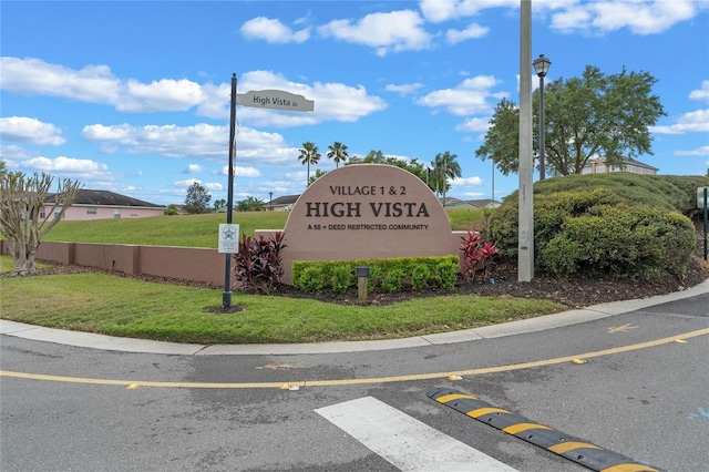 community / neighborhood sign featuring a lawn