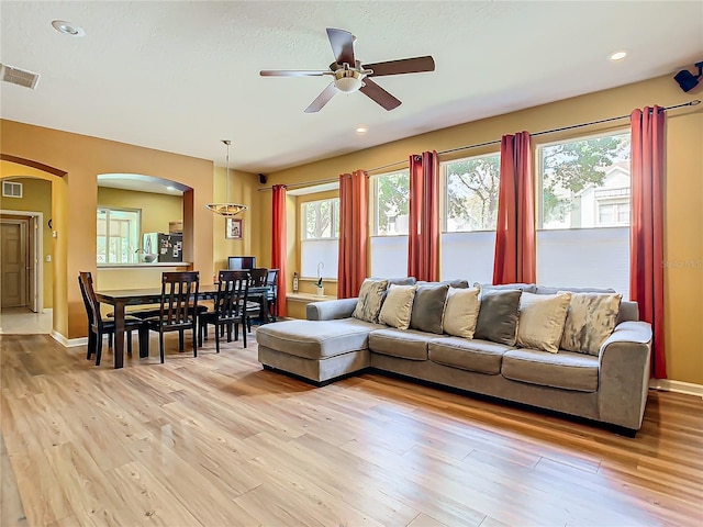 living room with ceiling fan and light hardwood / wood-style flooring