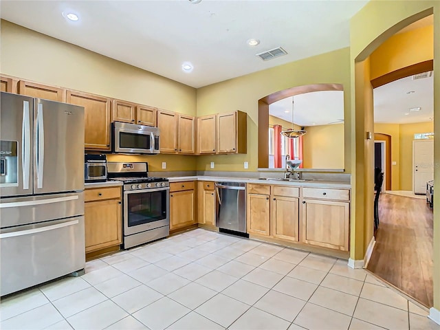 kitchen featuring light tile patterned floors, stainless steel appliances, and sink