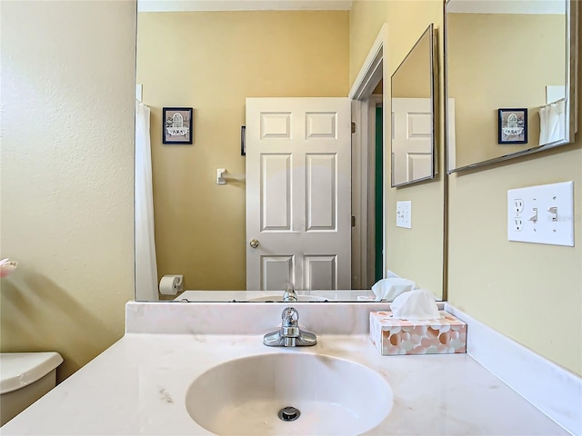 bathroom featuring vanity and toilet