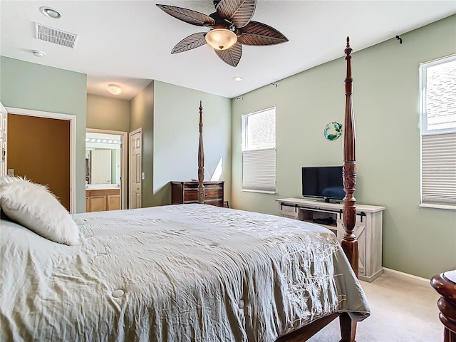 carpeted bedroom featuring ensuite bath and ceiling fan