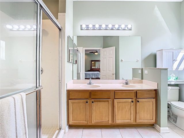 bathroom featuring vanity, toilet, an enclosed shower, and tile patterned floors