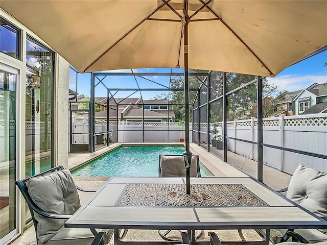 view of swimming pool with glass enclosure and a patio area