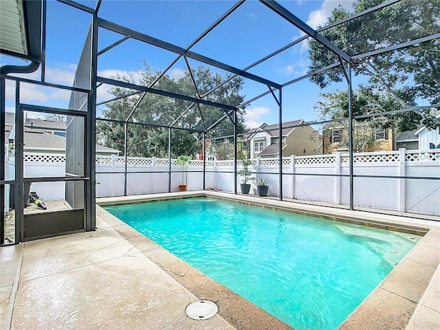 view of swimming pool with glass enclosure and a patio area