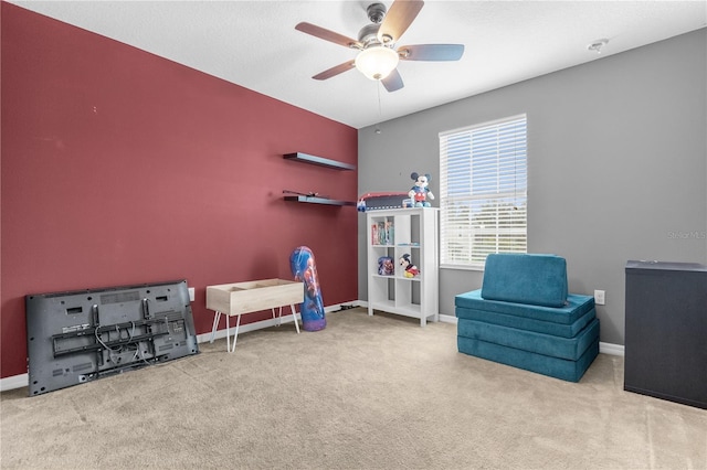 living area with ceiling fan and light colored carpet