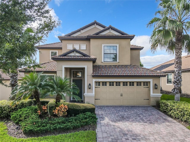 8920 Dove Valley Way, Davenport, FL 33896 - mediterranean / spanish home featuring decorative driveway, a tiled roof, and stucco siding