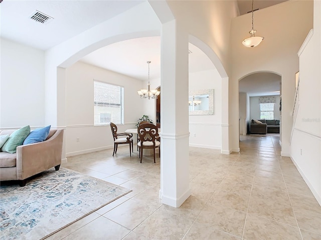 8920 Dove Valley Way, Davenport, FL 33896 - foyer with light tile patterned floors, a chandelier, arched walkways, baseboards, and a high ceiling