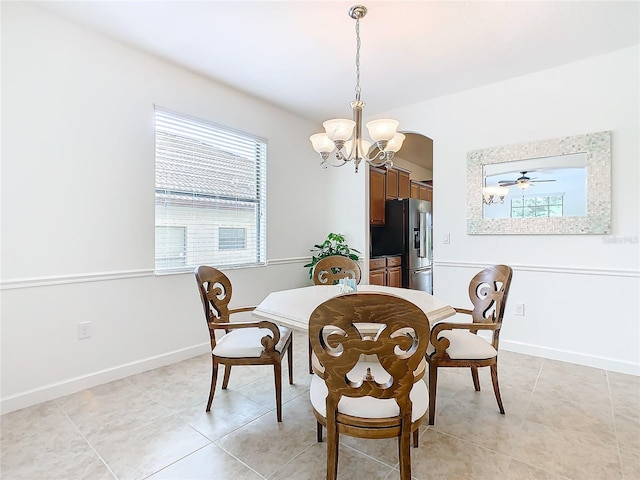 tiled dining room with ceiling fan with notable chandelier