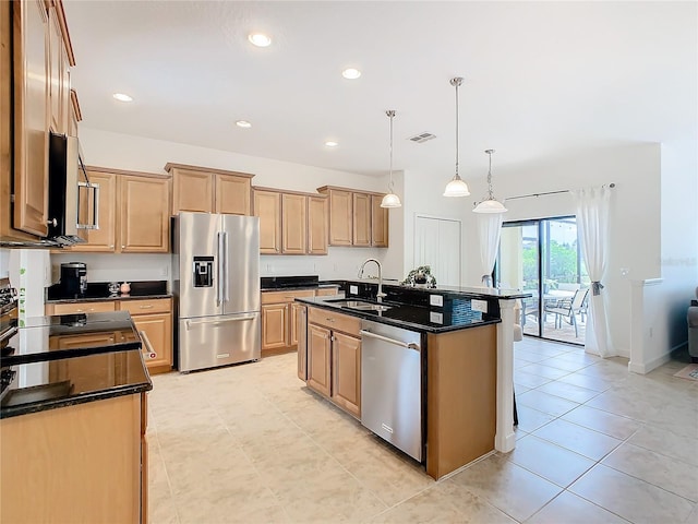 kitchen featuring hanging light fixtures, light tile patterned floors, stainless steel appliances, a kitchen island with sink, and sink