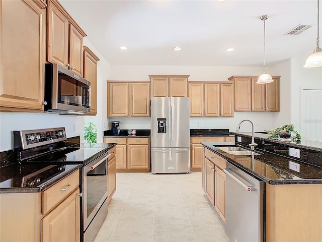 kitchen featuring light brown cabinets, hanging light fixtures, sink, appliances with stainless steel finishes, and dark stone counters