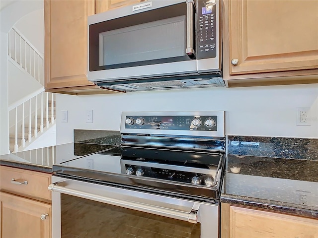 kitchen featuring dark stone countertops, light brown cabinets, and appliances with stainless steel finishes