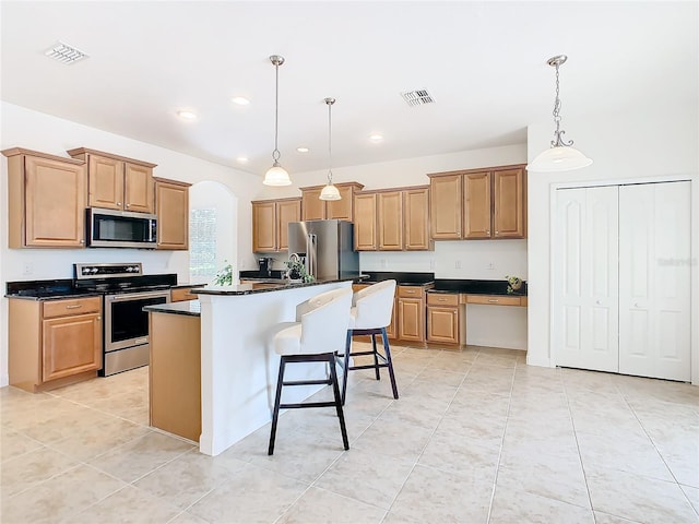 8920 Dove Valley Way, Davenport, FL 33896 - kitchen with appliances with stainless steel finishes, dark countertops, pendant lighting, light tile patterned flooring, and a kitchen island