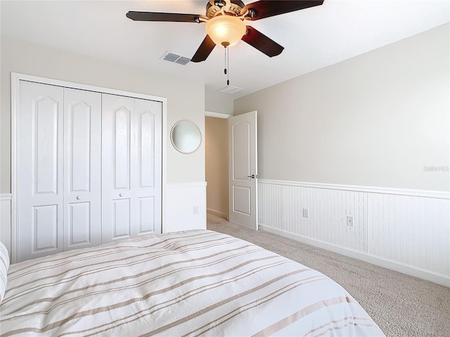 bedroom featuring light carpet, ceiling fan, and a closet