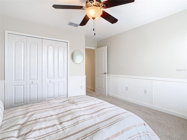 8920 Dove Valley Way, Davenport, FL 33896 - carpeted bedroom with wainscoting, a closet, and a ceiling fan
