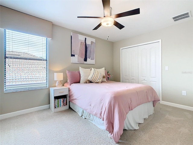 carpeted bedroom with ceiling fan and a closet