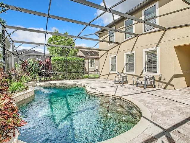 view of swimming pool with a patio, a lanai, and pool water feature