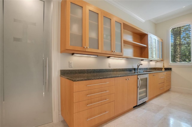 kitchen with sink, light brown cabinets, beverage cooler, dark stone countertops, and crown molding