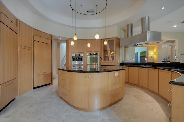 kitchen featuring sink, a raised ceiling, range hood, an island with sink, and light brown cabinetry