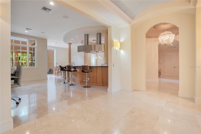 kitchen with a kitchen bar, crown molding, and an inviting chandelier