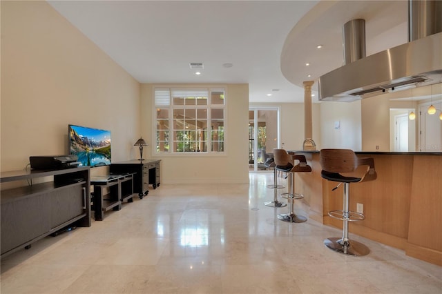 interior space featuring island exhaust hood and a kitchen bar