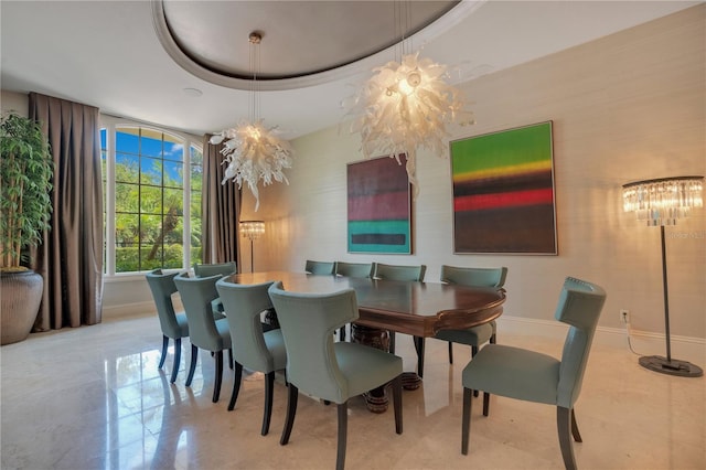 dining space with an inviting chandelier and a tray ceiling