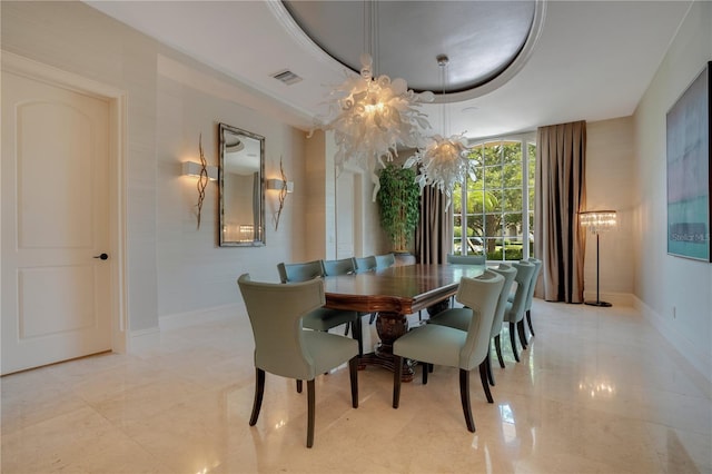 dining area featuring a chandelier and a raised ceiling