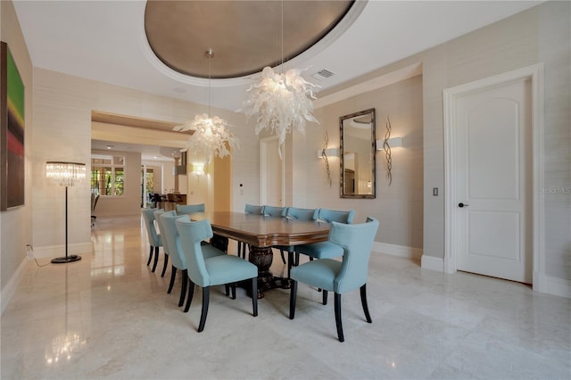 dining room with a chandelier and a raised ceiling