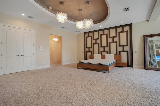 unfurnished bedroom with a tray ceiling, light carpet, and a notable chandelier