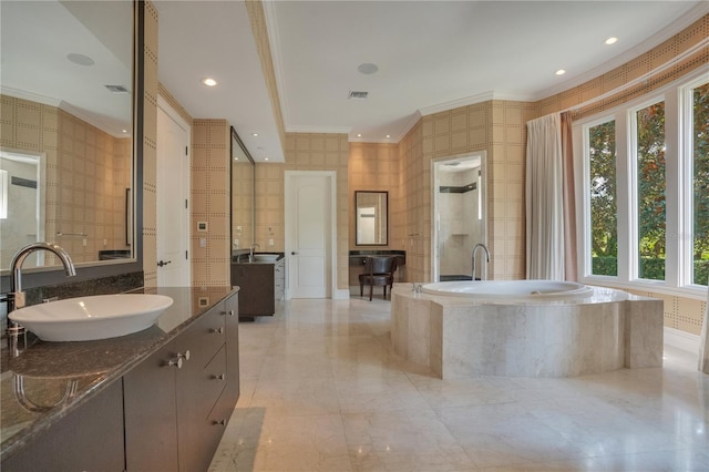 bathroom with tiled bath, plenty of natural light, vanity, and ornamental molding