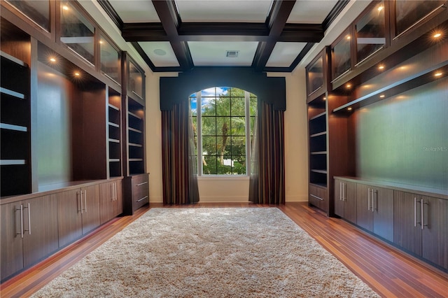 unfurnished office with built in shelves, beam ceiling, light hardwood / wood-style flooring, and coffered ceiling