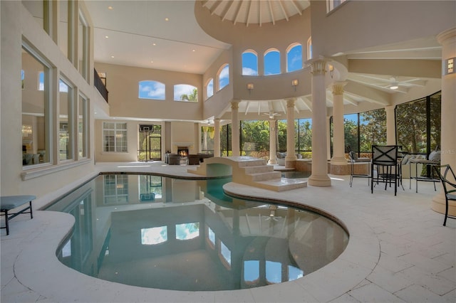 view of swimming pool with decorative columns and a jacuzzi