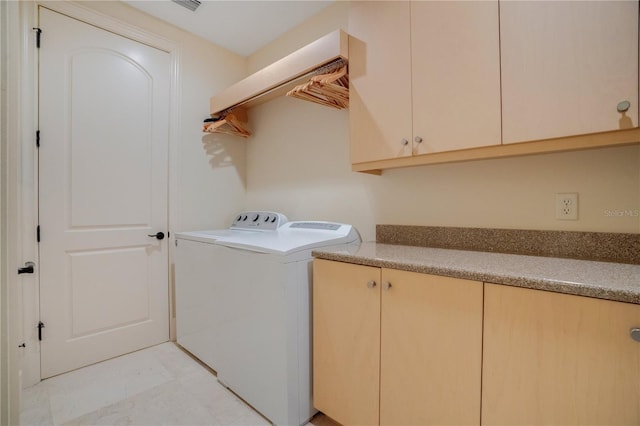 laundry area featuring washer and clothes dryer and cabinets